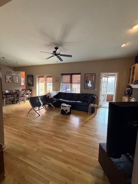 living area featuring light wood-style flooring and ceiling fan