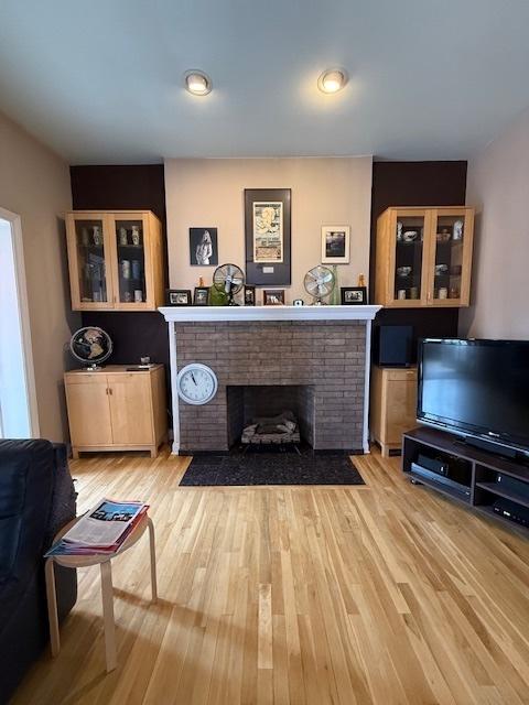 living room featuring light wood-type flooring and a fireplace