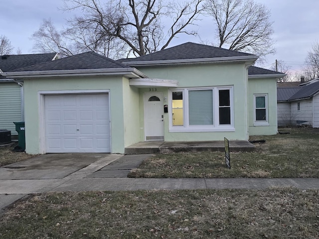 view of front of house featuring a garage, roof with shingles, concrete driveway, and stucco siding