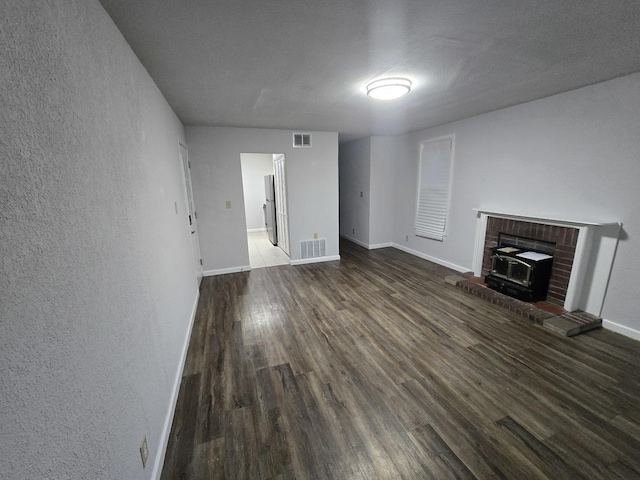 unfurnished living room featuring baseboards, visible vents, and wood finished floors