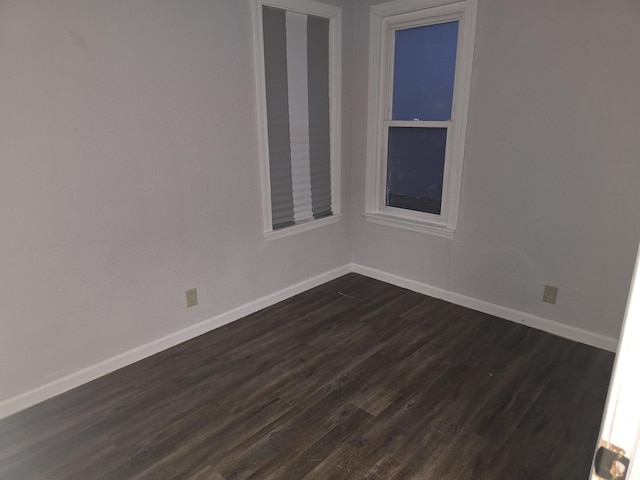 spare room with dark wood-style floors and baseboards