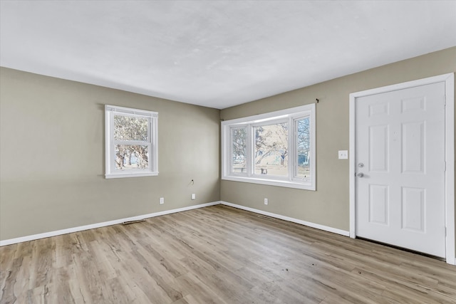 interior space featuring light wood-type flooring, visible vents, and baseboards