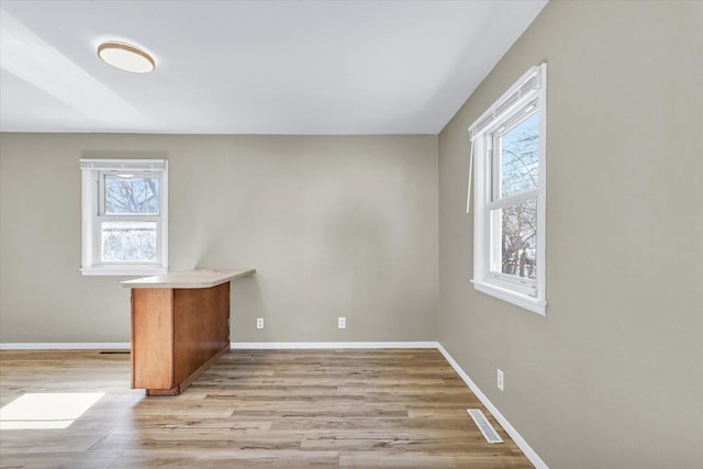 interior space with light wood-type flooring, baseboards, and visible vents