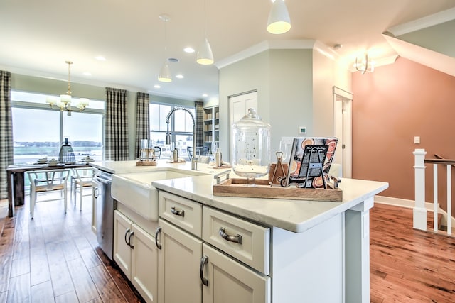 kitchen with a center island with sink, white cabinets, a view of city, a chandelier, and pendant lighting