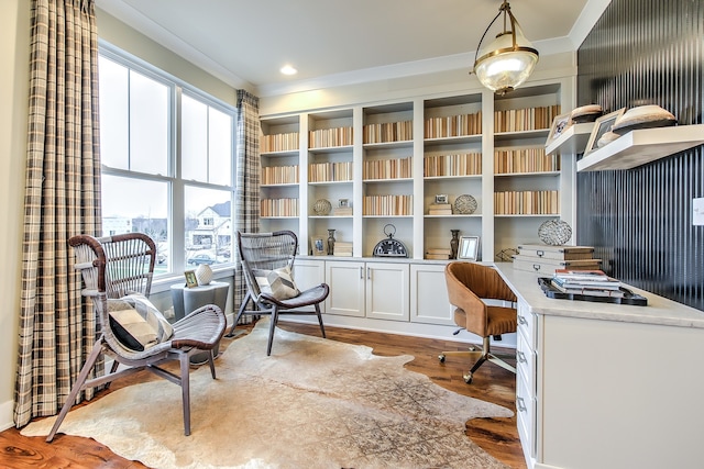 office with ornamental molding, built in desk, recessed lighting, and light wood-style floors