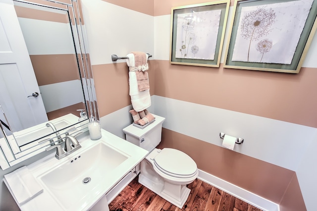 bathroom with a sink, wood finished floors, and toilet