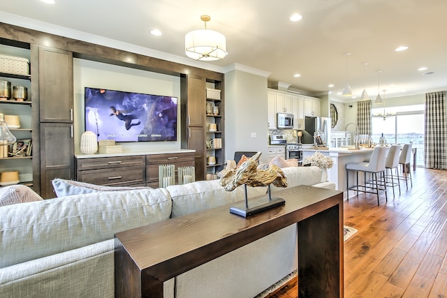 living area featuring ornamental molding, dark wood-style flooring, and recessed lighting