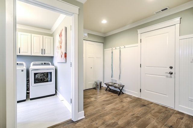 laundry area with separate washer and dryer, wood finished floors, visible vents, cabinet space, and crown molding