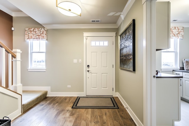 foyer entrance featuring stairway, light wood-type flooring, visible vents, and baseboards