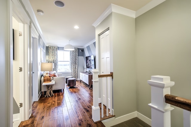 corridor with dark wood-style floors, recessed lighting, ornamental molding, an upstairs landing, and baseboards