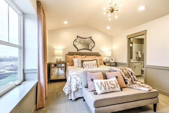 bedroom featuring lofted ceiling, light colored carpet, ensuite bathroom, and an inviting chandelier