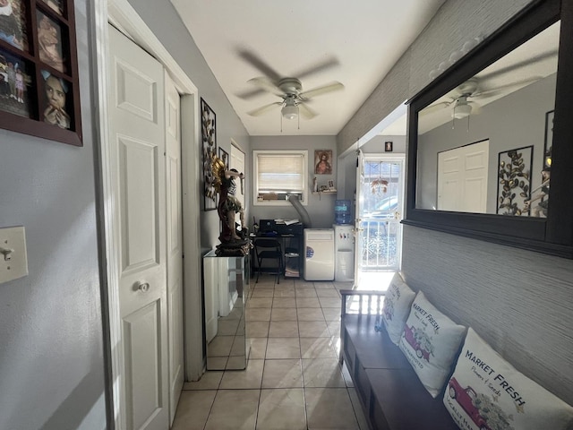 interior space featuring light tile patterned floors, ceiling fan, and laundry area