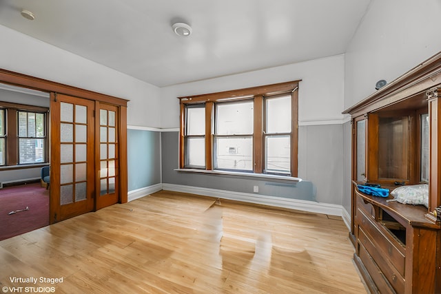 interior space featuring french doors, baseboards, and light wood finished floors