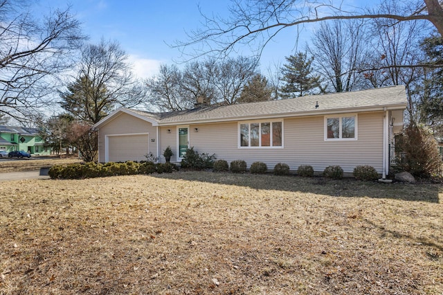 ranch-style house with a garage and a front lawn