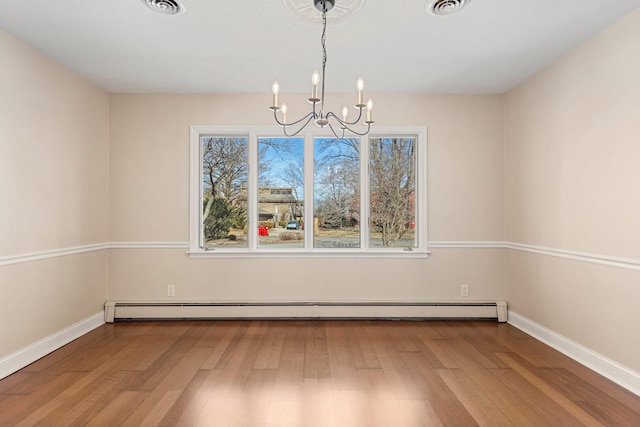 unfurnished dining area featuring a chandelier, a baseboard radiator, baseboards, and wood finished floors