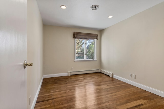 spare room featuring recessed lighting, wood finished floors, visible vents, and baseboards