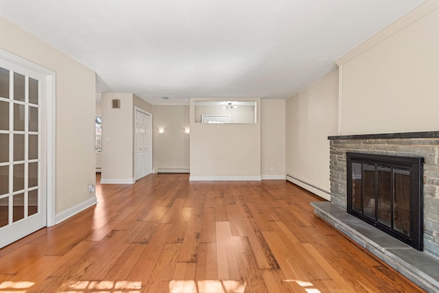 unfurnished living room featuring a baseboard radiator, light wood-style flooring, baseboard heating, a stone fireplace, and baseboards