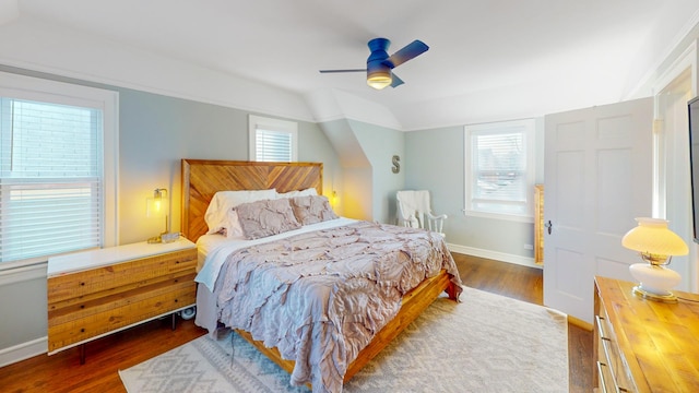 bedroom featuring dark wood finished floors, multiple windows, and vaulted ceiling