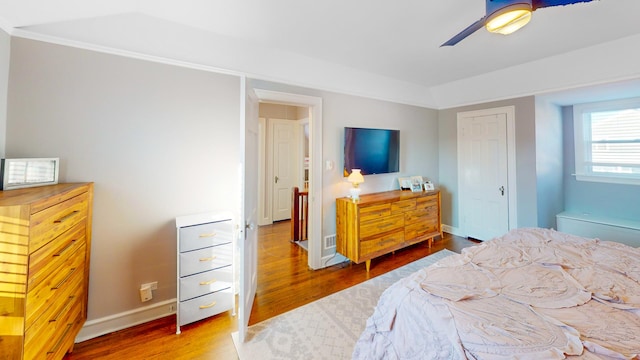 bedroom featuring ceiling fan, a closet, wood finished floors, and baseboards