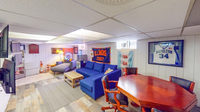 living area with a drop ceiling and wood finished floors