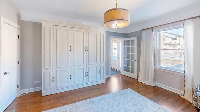 bedroom featuring dark wood-style flooring and baseboards