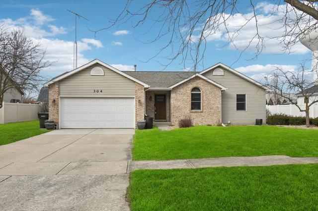 single story home with an attached garage, fence, concrete driveway, and a front yard