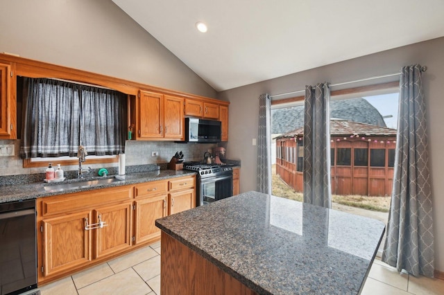 kitchen featuring tasteful backsplash, vaulted ceiling, stainless steel appliances, and a sink