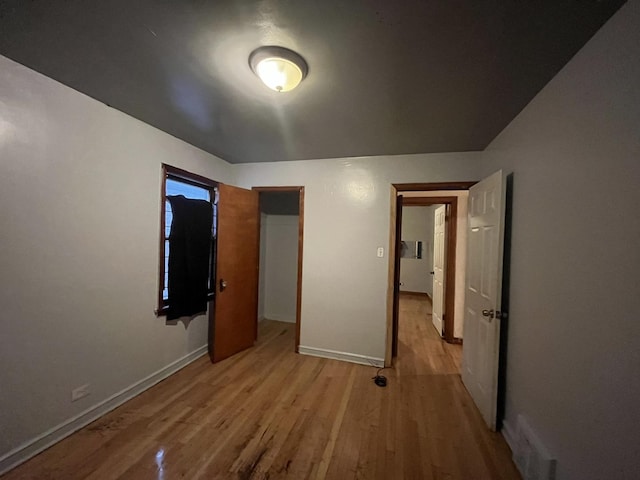 unfurnished bedroom with light wood finished floors and baseboards