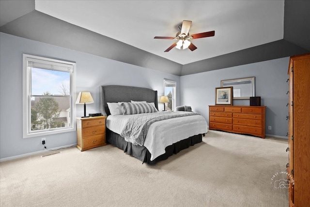 bedroom featuring baseboards, visible vents, vaulted ceiling, and light colored carpet