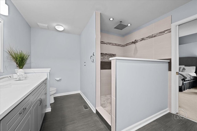 full bath with visible vents, baseboards, toilet, walk in shower, and vanity