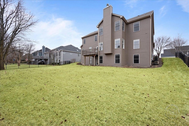 rear view of house featuring a chimney, a residential view, a fenced backyard, and a lawn