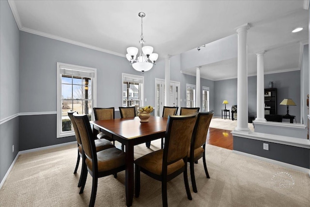 dining space with decorative columns, crown molding, baseboards, and a notable chandelier