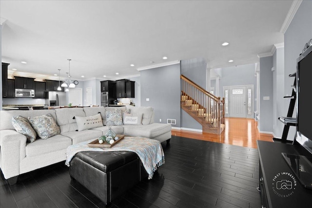 living room with crown molding, stairs, visible vents, and wood finished floors