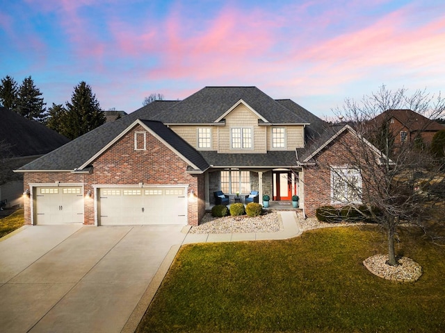 view of front of house featuring a garage, a lawn, concrete driveway, and brick siding