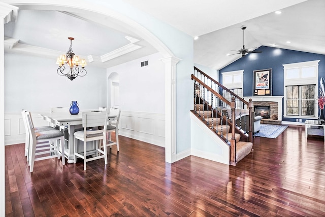 dining space featuring a raised ceiling, a fireplace, stairway, and hardwood / wood-style flooring