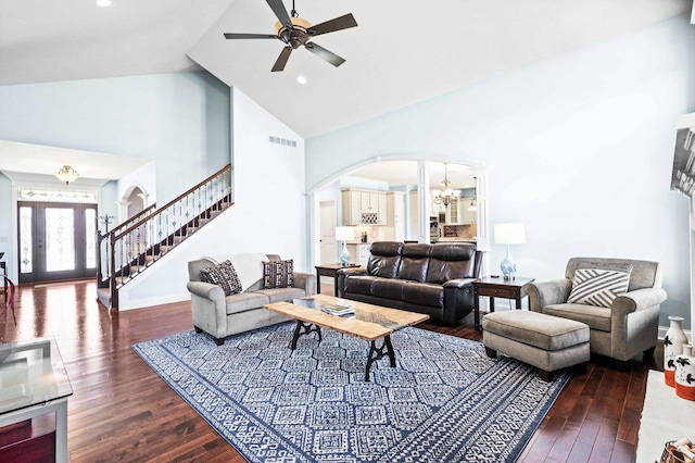 living room featuring visible vents, arched walkways, wood finished floors, stairs, and ceiling fan with notable chandelier