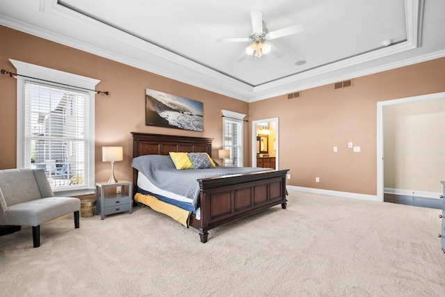 bedroom featuring light carpet, crown molding, visible vents, and a tray ceiling