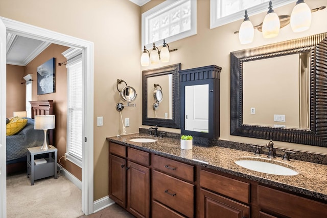 bathroom featuring ensuite bathroom, double vanity, a sink, and crown molding