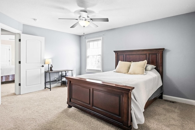 bedroom with light carpet, ceiling fan, visible vents, and baseboards