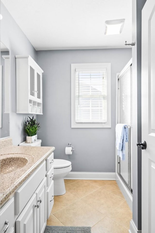 full bathroom featuring a stall shower, tile patterned floors, baseboards, and vanity