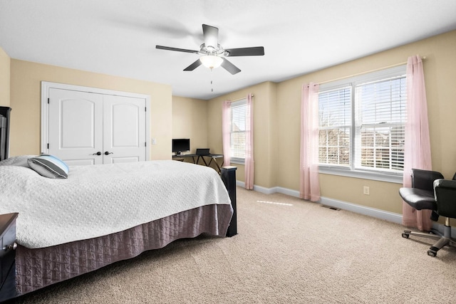 bedroom featuring light colored carpet, visible vents, a ceiling fan, baseboards, and a closet