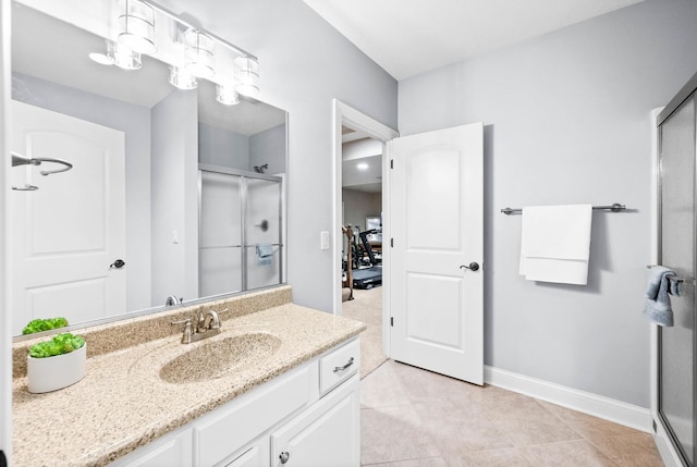 full bathroom featuring a stall shower, baseboards, and vanity