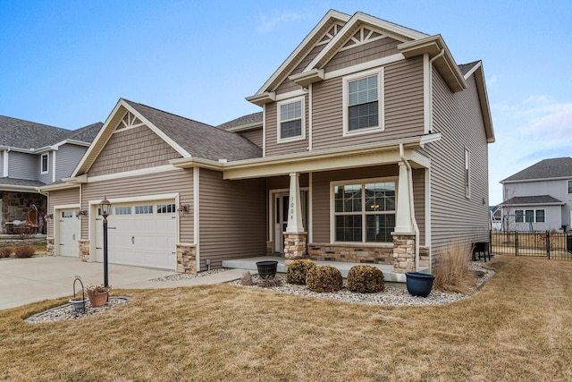 craftsman house featuring a porch, a garage, fence, stone siding, and a front lawn