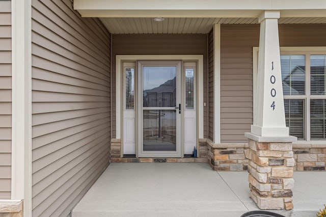 property entrance featuring stone siding and a porch