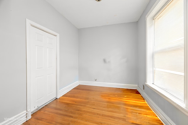 spare room featuring baseboards and light wood-style floors