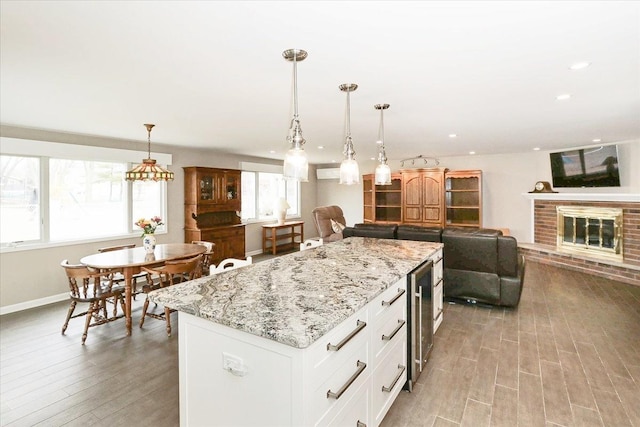 kitchen with light wood-type flooring, a healthy amount of sunlight, and a fireplace