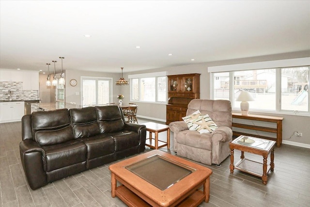 living area with wood tiled floor, baseboards, and recessed lighting