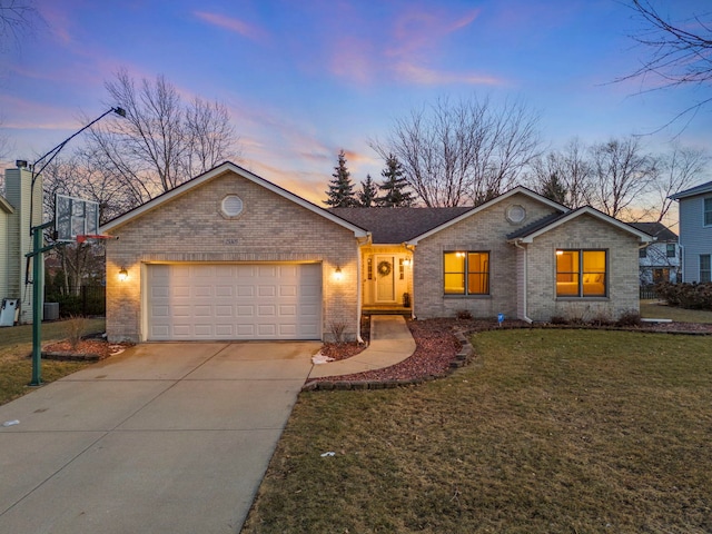 single story home with a garage, brick siding, concrete driveway, and a yard