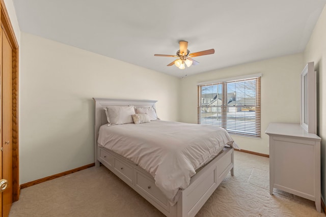 bedroom featuring light carpet, ceiling fan, and baseboards