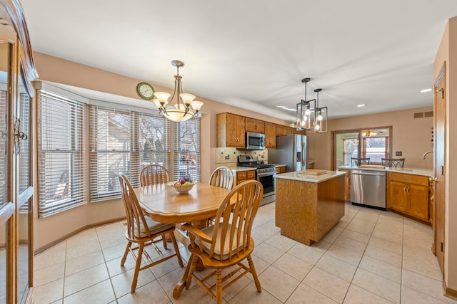 dining area featuring light tile patterned floors, visible vents, baseboards, and an inviting chandelier